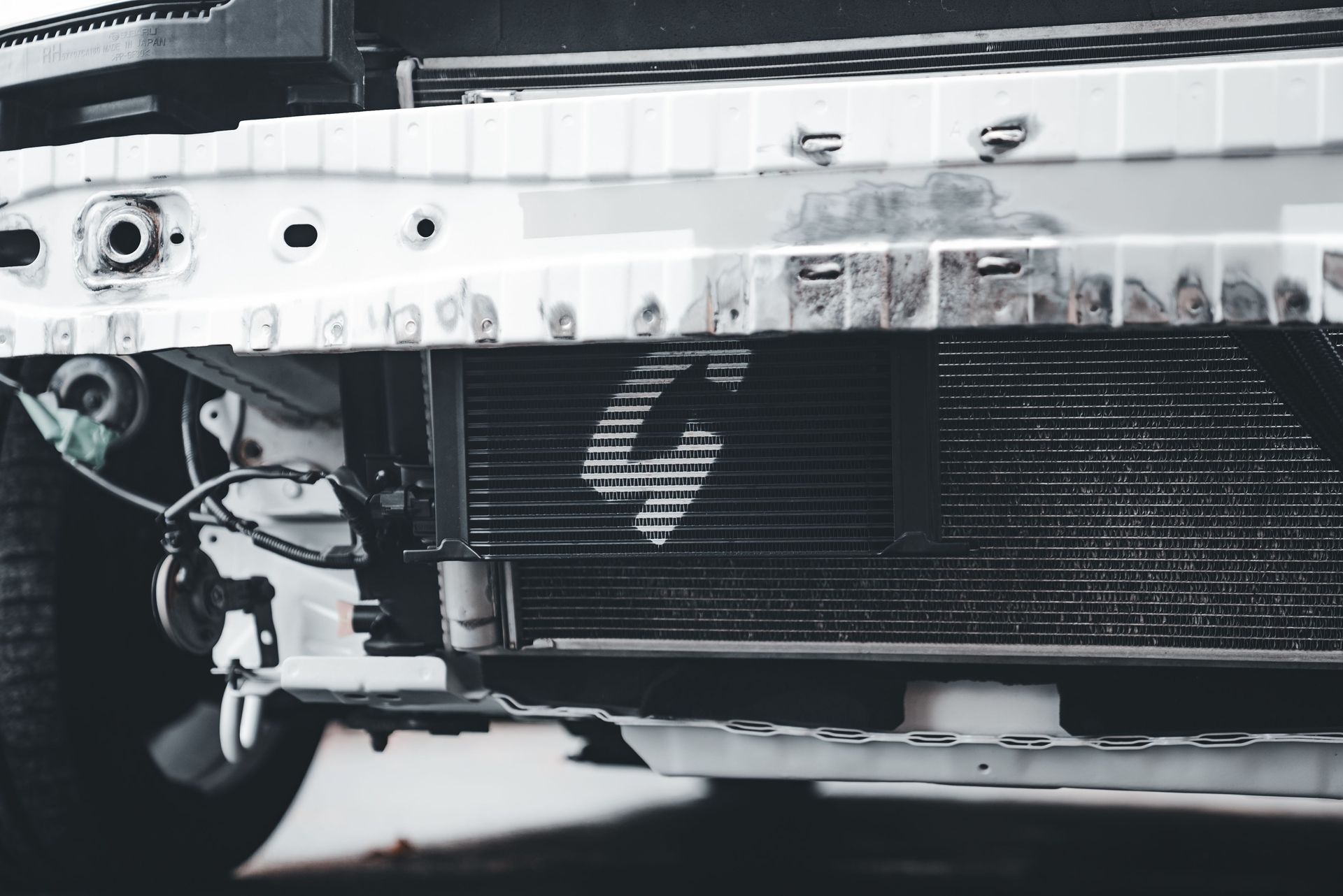 Detailed image of a car radiator and front bumper highlighting mechanical components.